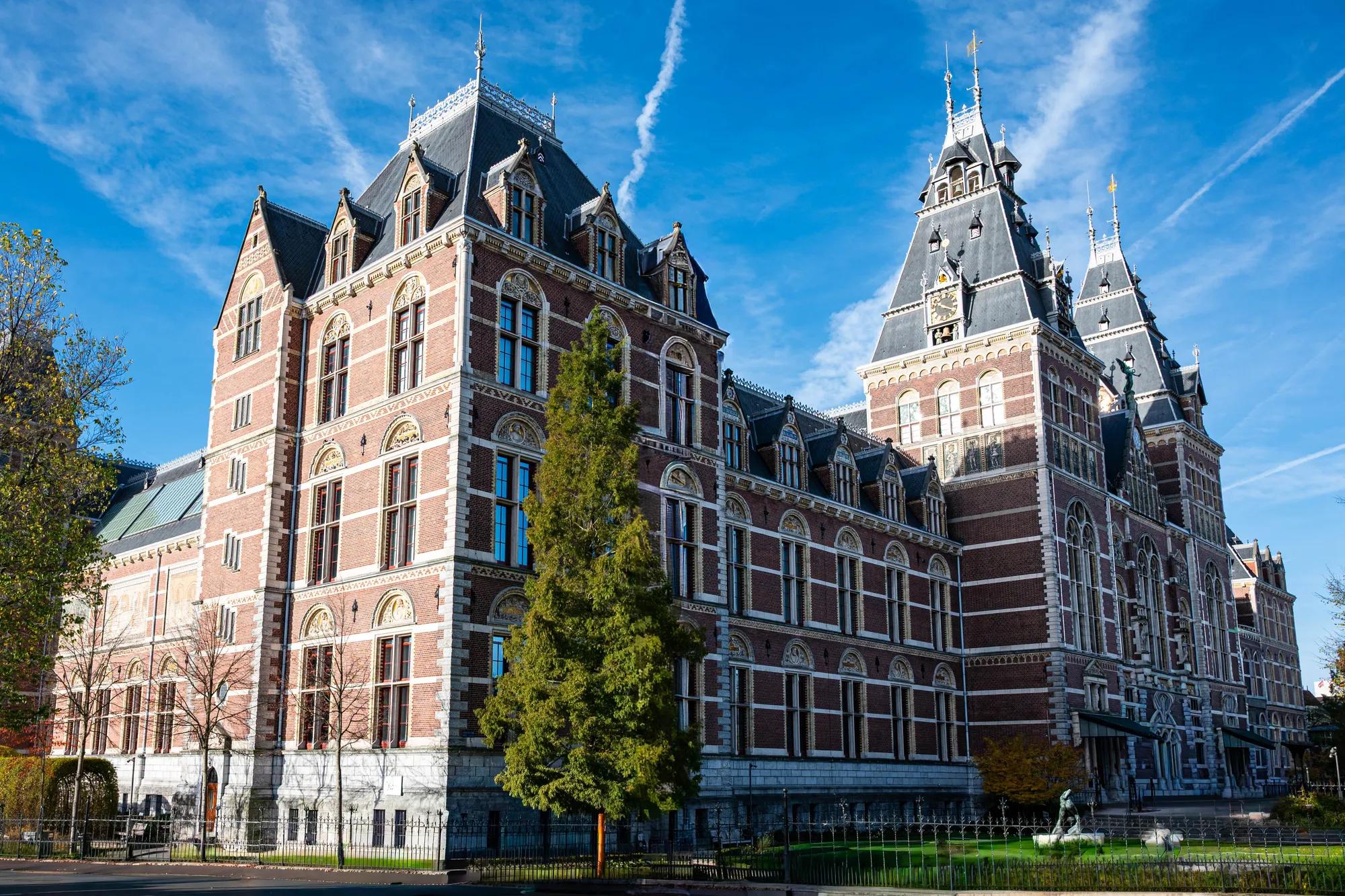 Side view of Rijksmuseum in Amsterdam, showcasing its iconic architecture on a clear day.