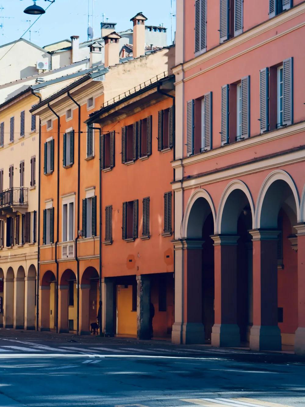 A row of buildings form a slumberous street in Bologna.