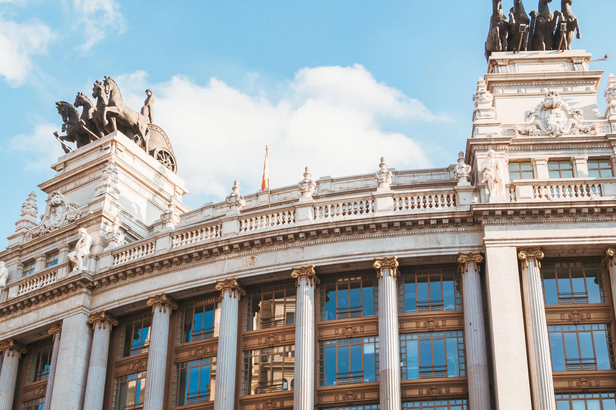 Elegant historic building facade with ornate sculptures under a clear sky.