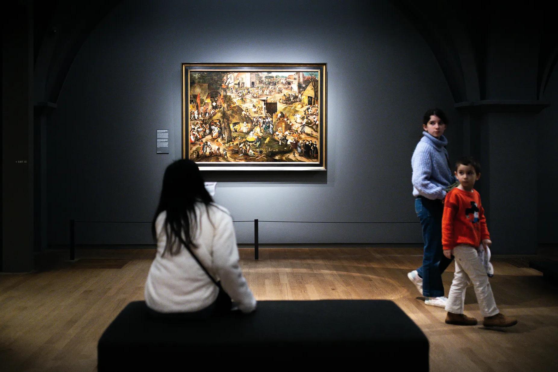 A woman and a child looking at a painting.